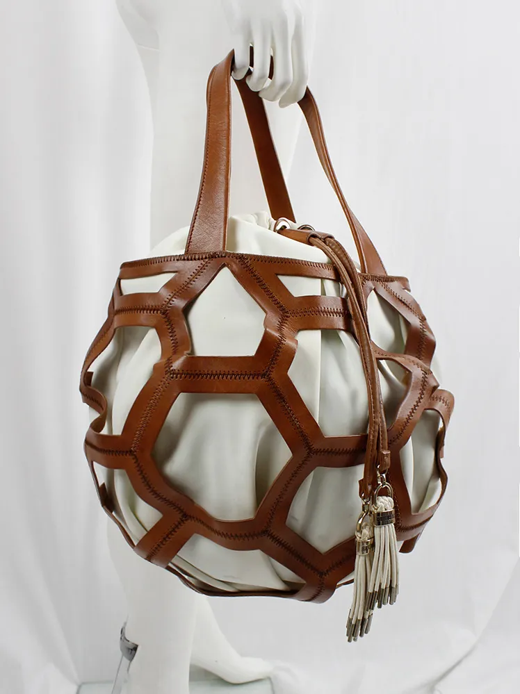 Dirk Bikkembergs brown leather football bag with hexagonal cutouts over a white fabric bag